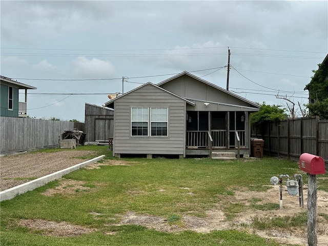 230 Lola Johnson, Corpus Christi, TX 78418 - back of property featuring fence, a sunroom, and a lawn