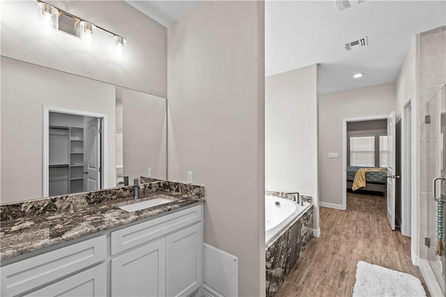 4133 Midlands St, Corpus Christi, TX 78414 - bathroom featuring vanity, a shower stall, a garden tub, wood finished floors, and connected bathroom