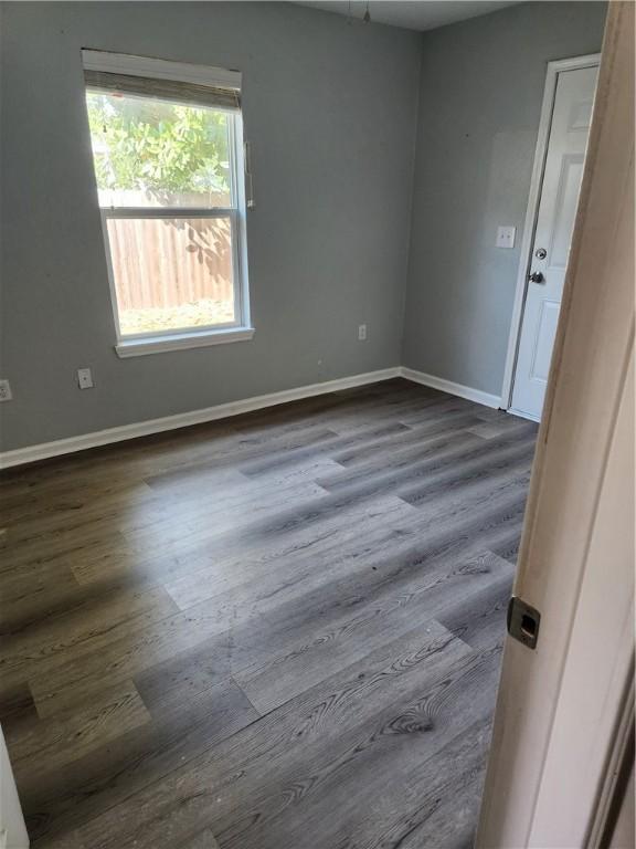 413 S 13th St, Aransas Pass, TX 78336 - spare room featuring dark wood-type flooring and baseboards