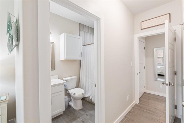 bathroom featuring vanity, hardwood / wood-style flooring, and toilet