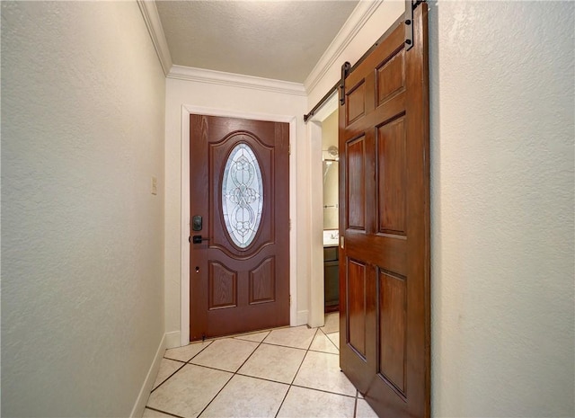 entryway with a barn door, ornamental molding, a textured ceiling, and light tile patterned floors