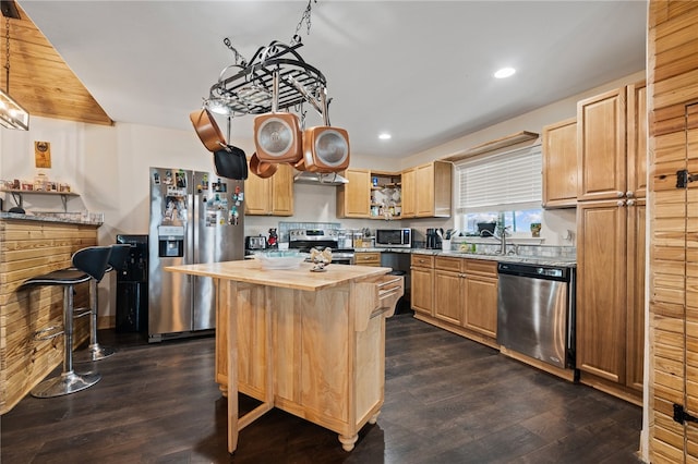 kitchen with butcher block countertops, a kitchen island, appliances with stainless steel finishes, dark hardwood / wood-style floors, and light brown cabinetry