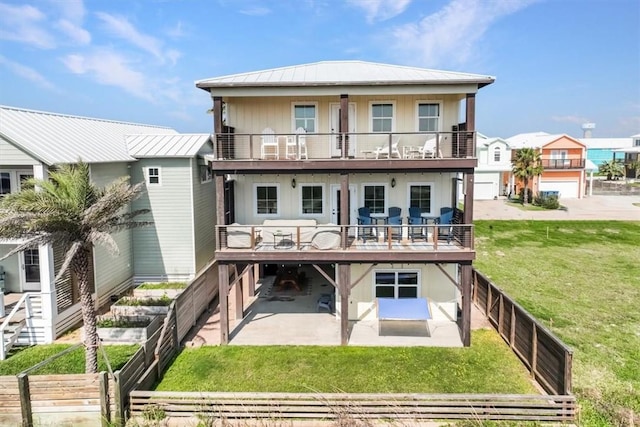 rear view of house with a yard, a patio area, and a balcony