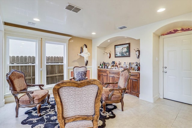 dining space with bar area and light tile patterned floors