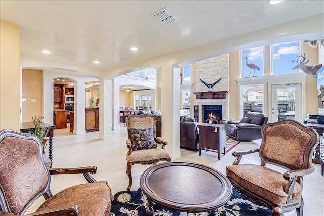 tiled living room with a stone fireplace