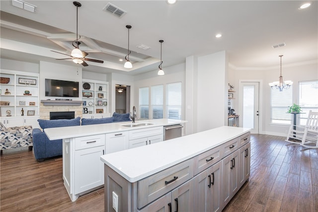 kitchen featuring dishwasher, sink, dark wood-type flooring, a spacious island, and decorative light fixtures