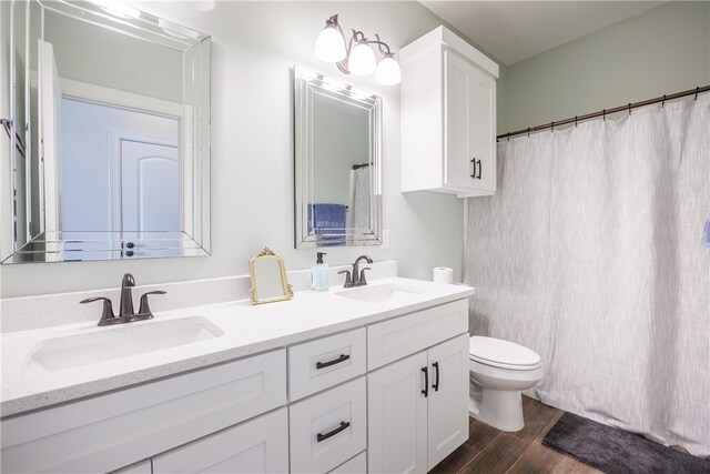 bathroom with hardwood / wood-style floors, vanity, and toilet