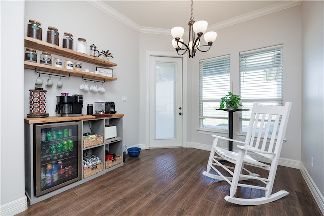 dining room featuring dark hardwood / wood-style flooring, crown molding, a chandelier, bar area, and wine cooler