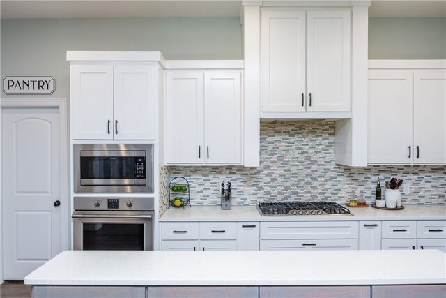 kitchen featuring white cabinets, appliances with stainless steel finishes, and backsplash