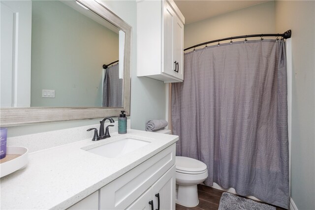 bathroom with wood-type flooring, vanity, and toilet