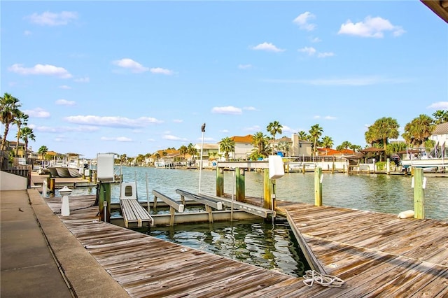 view of dock featuring a water view, a residential view, and boat lift