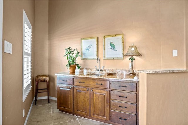 bar featuring a sink and light tile patterned flooring
