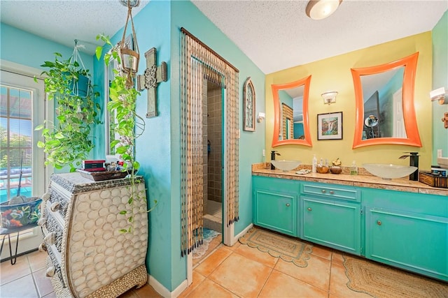 15718 Escapade St, Corpus Christi, TX 78418 - full bath featuring a textured ceiling, tile patterned flooring, double vanity, and tiled shower