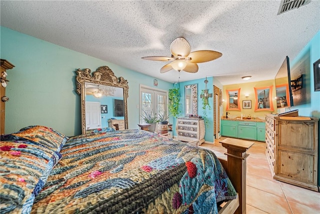 15718 Escapade St, Corpus Christi, TX 78418 - bedroom with light tile patterned floors, a textured ceiling, connected bathroom, a ceiling fan, and french doors