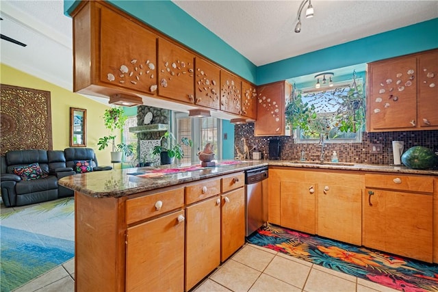 15718 Escapade St, Corpus Christi, TX 78418 - kitchen with stainless steel dishwasher, light tile patterned flooring, a peninsula, brown cabinetry, and tasteful backsplash