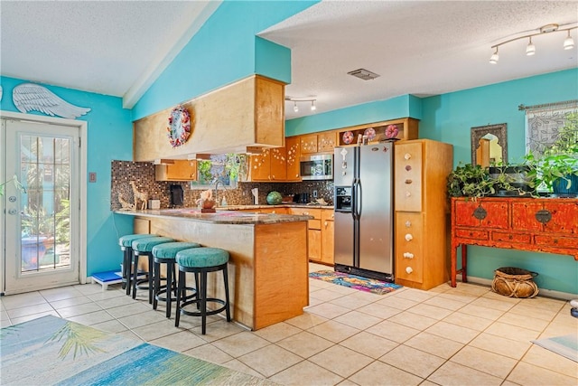 15718 Escapade St, Corpus Christi, TX 78418 - kitchen featuring appliances with stainless steel finishes, a textured ceiling, track lighting, tasteful backsplash, and a peninsula