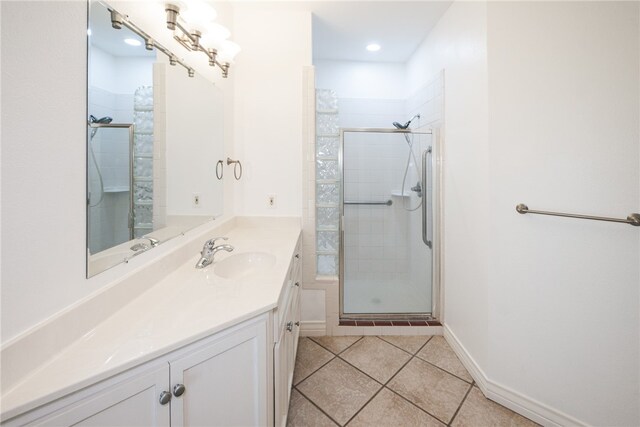 bathroom with walk in shower, vanity, and tile patterned floors