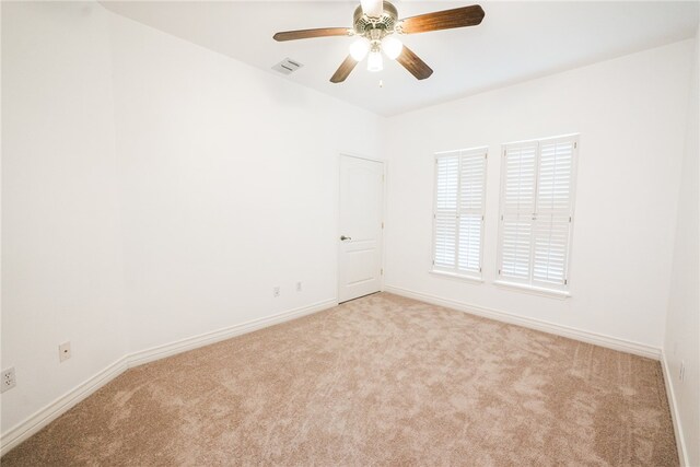 empty room featuring ceiling fan and light carpet