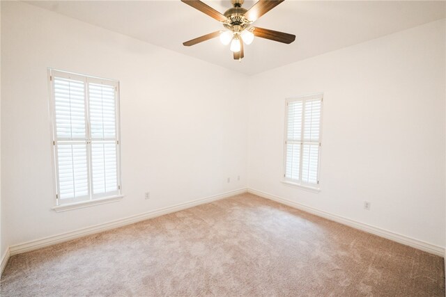 empty room featuring light colored carpet and ceiling fan