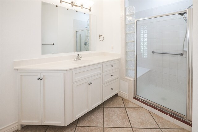 bathroom with walk in shower, tile patterned flooring, and vanity