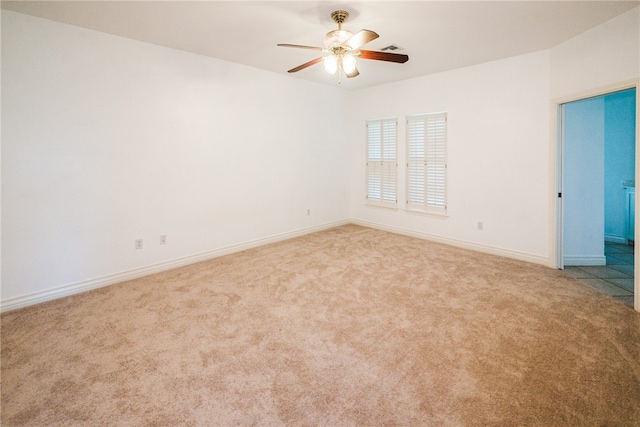 empty room featuring light carpet and ceiling fan