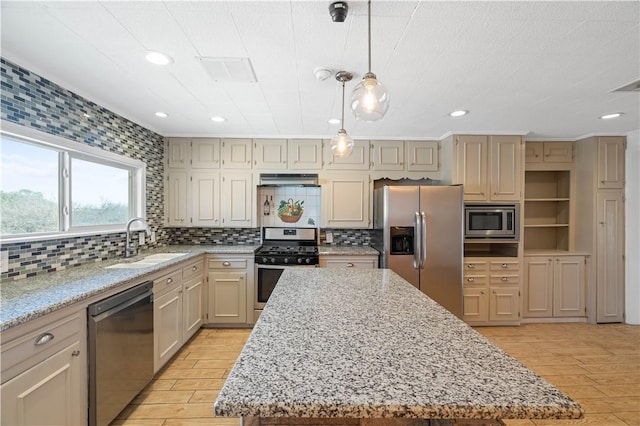 kitchen with light stone counters, a center island, appliances with stainless steel finishes, light wood-style floors, and a sink