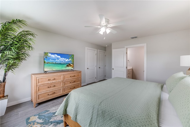 bedroom featuring connected bathroom, ceiling fan, and light hardwood / wood-style flooring