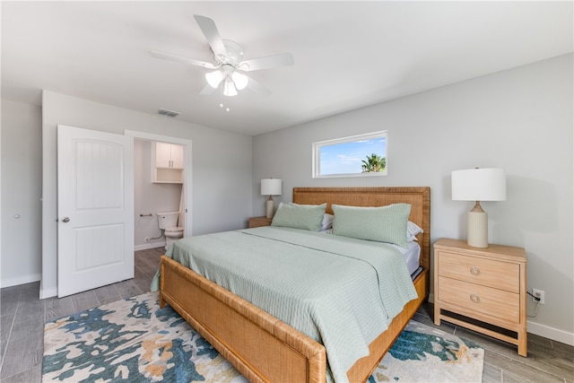 bedroom with dark wood-type flooring, ceiling fan, and ensuite bath