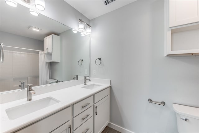 bathroom with curtained shower, vanity, and toilet