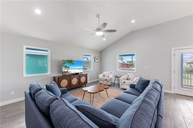 living room with light hardwood / wood-style floors, ceiling fan, and vaulted ceiling