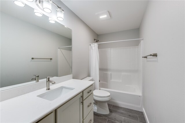 full bathroom with hardwood / wood-style floors, vanity, shower / bath combination with curtain, and toilet