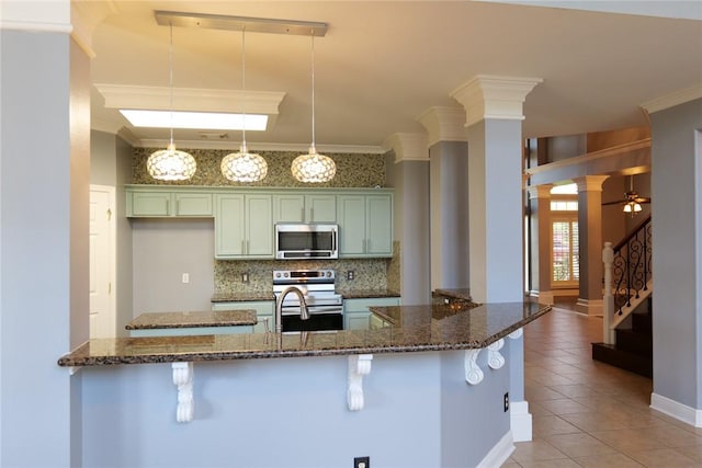 5710 Neustadt Dr, Corpus Christi, TX 78414 - kitchen with stainless steel appliances, light tile patterned floors, tasteful backsplash, a kitchen bar, and ornate columns