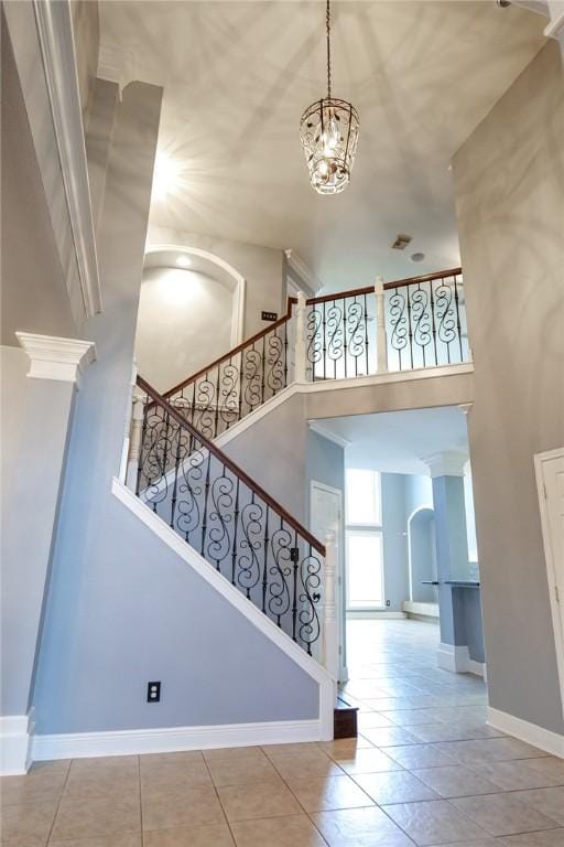 5710 Neustadt Dr, Corpus Christi, TX 78414 - stairs featuring a towering ceiling, baseboards, arched walkways, and a chandelier