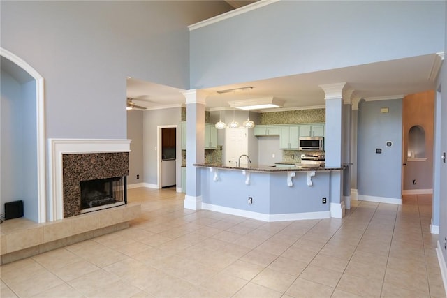 5710 Neustadt Dr, Corpus Christi, TX 78414 - kitchen featuring stainless steel appliances, ornamental molding, decorative backsplash, dark stone counters, and a peninsula
