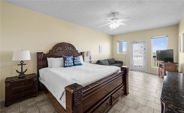 bedroom with access to exterior, ceiling fan, light tile patterned floors, and a textured ceiling