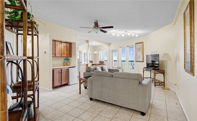 tiled living room featuring ceiling fan and a textured ceiling