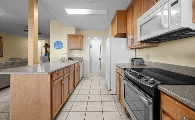 kitchen with white appliances, a textured ceiling, ceiling fan, sink, and light tile patterned floors