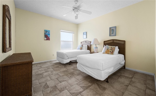 bedroom with ceiling fan and a textured ceiling