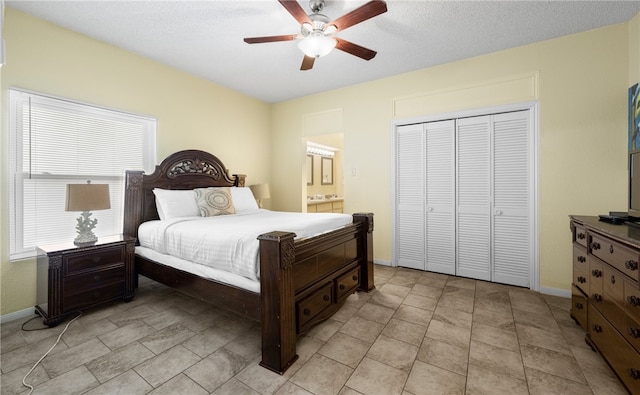 bedroom with ensuite bath, a textured ceiling, ceiling fan, light tile patterned floors, and a closet