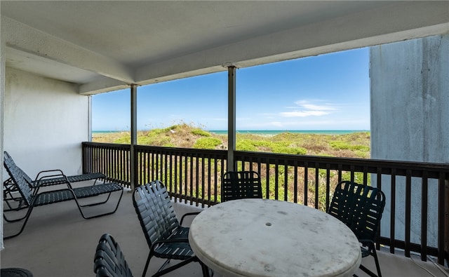 sunroom featuring a water view