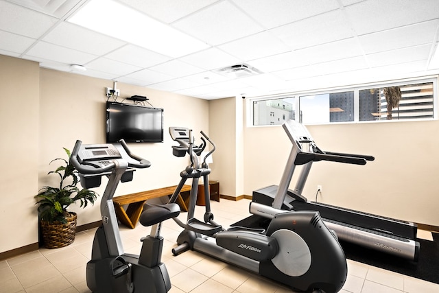 workout area with a drop ceiling and light tile patterned floors