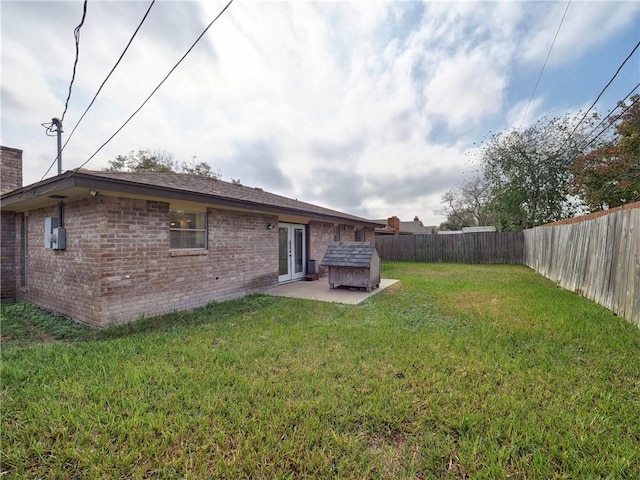 back of property featuring a patio area, a yard, and french doors