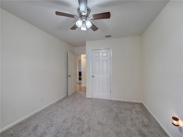 carpeted spare room with ceiling fan