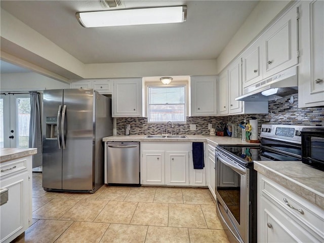 kitchen featuring white cabinets, light tile patterned floors, stainless steel appliances, and sink