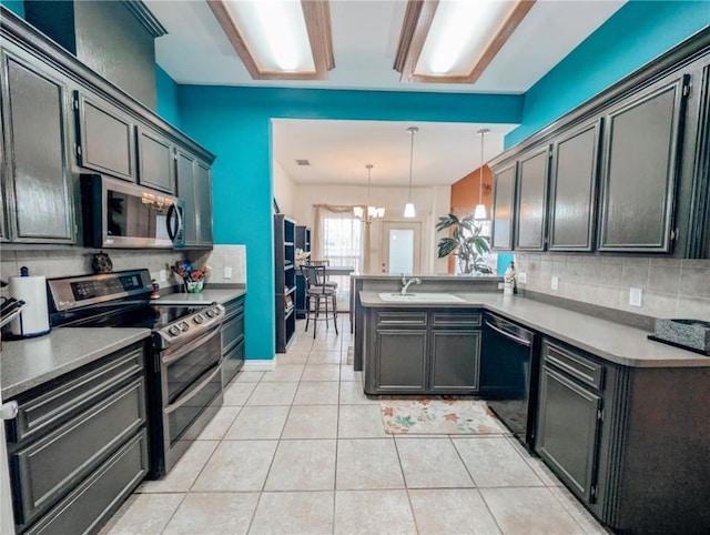 kitchen featuring sink, hanging light fixtures, light tile patterned floors, kitchen peninsula, and stainless steel appliances