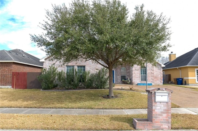 view of property hidden behind natural elements with a front yard