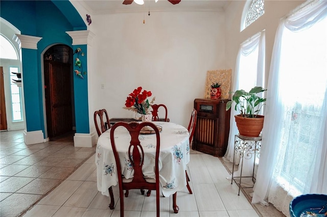 tiled dining space featuring crown molding, ceiling fan, and plenty of natural light