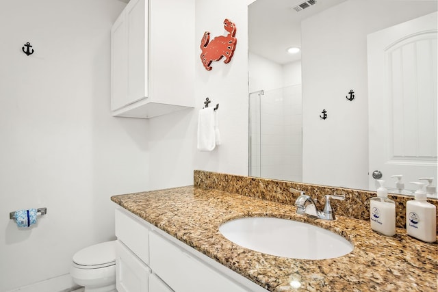 bathroom featuring walk in shower, vanity, and toilet