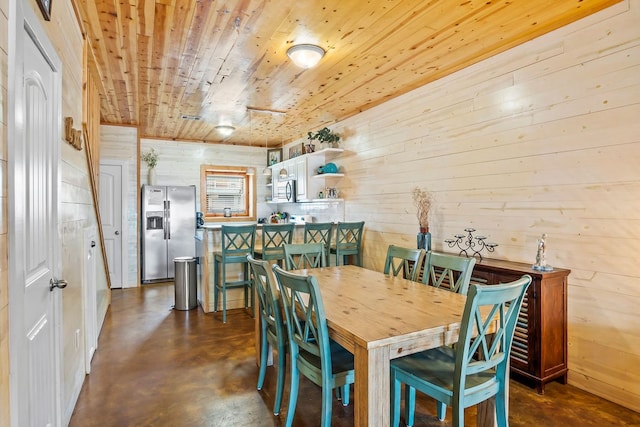 dining space with wooden walls and wood ceiling