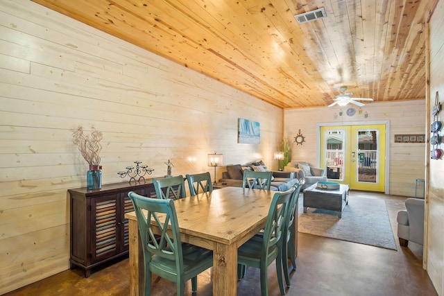 dining space with french doors, wooden walls, ceiling fan, and wood ceiling